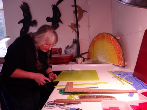 Sharon Svenson cuts strips of glass. 