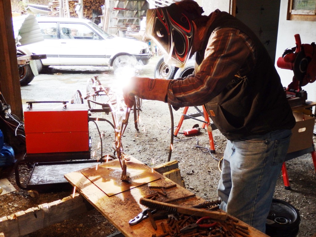 Gene Kennedy welds re-bar into the shape of a dog. (Emily Files)
