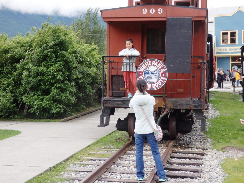 Tourists take pictures with a White Pass and Yukon Route Railroad train car. (Emily Files)
